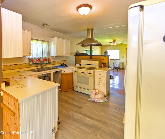 464 E Lincoln, Priest River, ID 83856 - kitchen with island exhaust hood, white gas range oven, a peninsula, a sink, and plenty of natural light