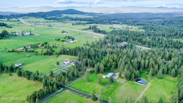 7672 W Carnie Rd, Coeur Dalene, ID 83814 - aerial view of property's location featuring a mountain backdrop, rural landscape, and a heavily wooded area