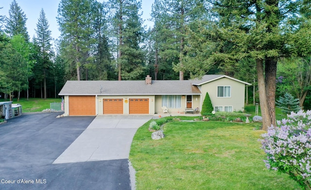 7672 W Carnie Rd, Coeur Dalene, ID 83814 - split level home with a front lawn, driveway, a chimney, and roof with shingles