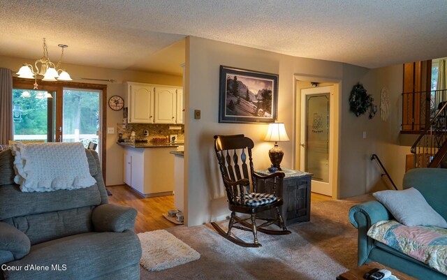 7672 W Carnie Rd, Coeur Dalene, ID 83814 - living room with healthy amount of natural light, light wood-style flooring, a textured ceiling, and a chandelier