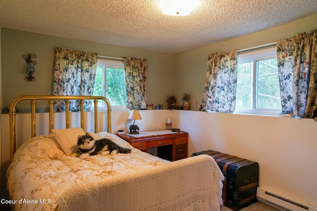 7672 W Carnie Rd, Coeur Dalene, ID 83814 - bedroom featuring baseboard heating, a textured ceiling, and multiple windows