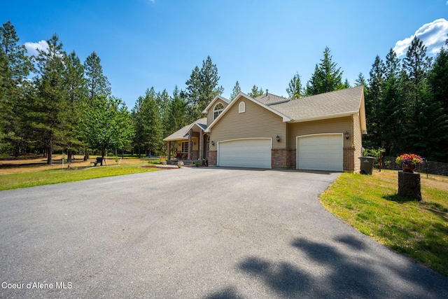 23216 E Morris Rd, Newman Lake, WA 99025 - view of front of house featuring driveway, an attached garage, and brick siding
