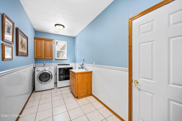 23216 E Morris Rd, Newman Lake, WA 99025 - laundry area featuring cabinet space, independent washer and dryer, a wainscoted wall, light tile patterned floors, and a textured ceiling