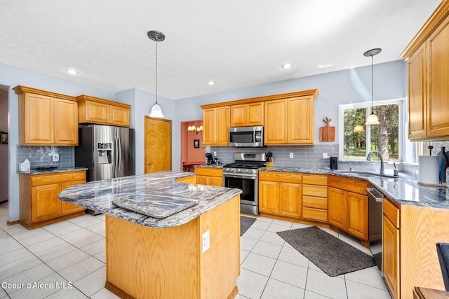23216 E Morris Rd, Newman Lake, WA 99025 - kitchen featuring stainless steel appliances, a sink, tasteful backsplash, a center island, and light tile patterned floors