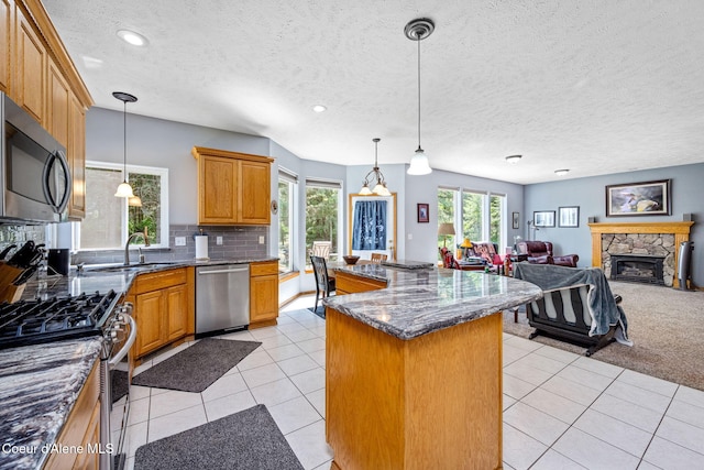 23216 E Morris Rd, Newman Lake, WA 99025 - kitchen with appliances with stainless steel finishes, a center island, a sink, open floor plan, and light tile patterned floors
