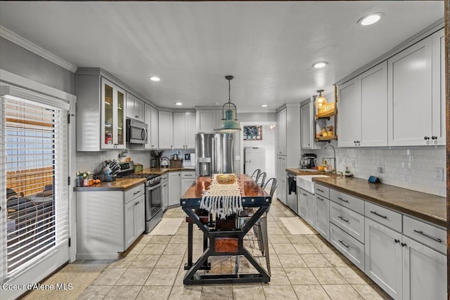 115 Fifth St, Osburn, ID 83849 - kitchen with stainless steel appliances, a sink, gray cabinets, ornamental molding, and decorative backsplash