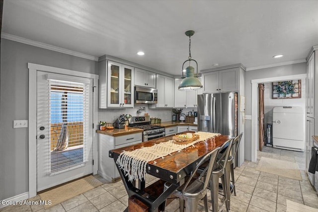 115 Fifth St, Osburn, ID 83849 - kitchen featuring stainless steel appliances, gray cabinetry, crown molding, glass insert cabinets, and decorative backsplash