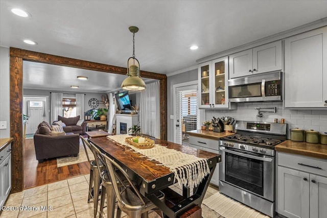 115 Fifth St, Osburn, ID 83849 - kitchen with stainless steel appliances, tasteful backsplash, plenty of natural light, glass insert cabinets, and recessed lighting