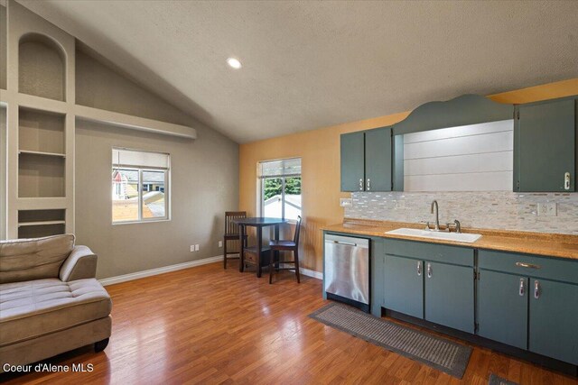 115 Fifth St, Osburn, ID 83849 - kitchen featuring stainless steel dishwasher, a sink, decorative backsplash, baseboards, and light wood-style flooring