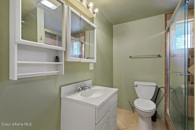 115 Fifth St, Osburn, ID 83849 - bathroom featuring vanity, a stall shower, toilet, a textured wall, and tile patterned flooring
