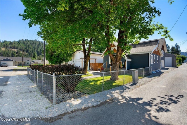115 Fifth St, Osburn, ID 83849 - view of front facade featuring a fenced front yard, a detached garage, and a shingled roof