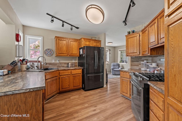 67 Spur Dr, Sandpoint, ID 83864 - kitchen featuring freestanding refrigerator, track lighting, stainless steel gas range oven, light wood-type flooring, and decorative backsplash
