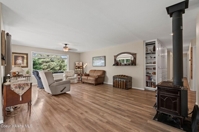 67 Spur Dr, Sandpoint, ID 83864 - living room featuring a wood stove, wood finished floors, and a ceiling fan