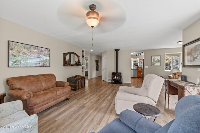 67 Spur Dr, Sandpoint, ID 83864 - living room featuring a wood stove, light wood-style floors, and a ceiling fan