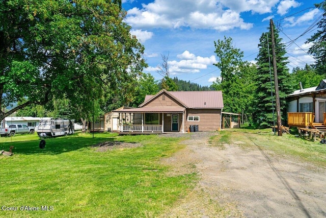 510 S 2nd St, Saint Maries, ID 83861 - view of front of home with a porch, dirt driveway, a front yard, and a metal roof