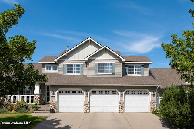 2867 W Tours Dr, Coeur Dalene, ID 83815 - view of front of house with stone siding, concrete driveway, a garage, and board and batten siding