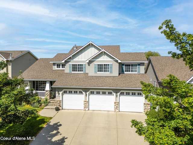 2867 W Tours Dr, Coeur Dalene, ID 83815 - view of front of house featuring board and batten siding, concrete driveway, stone siding, a garage, and a shingled roof