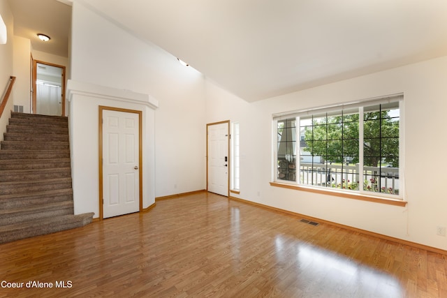 2867 W Tours Dr, Coeur Dalene, ID 83815 - unfurnished room featuring wood finished floors, stairs, and high vaulted ceiling