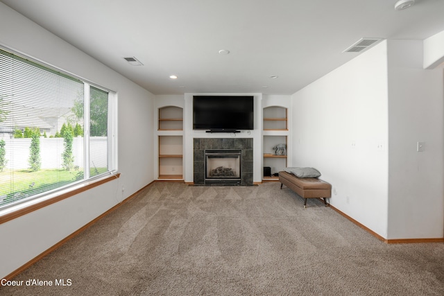 2867 W Tours Dr, Coeur Dalene, ID 83815 - unfurnished living room with carpet flooring, a tile fireplace, and built in features