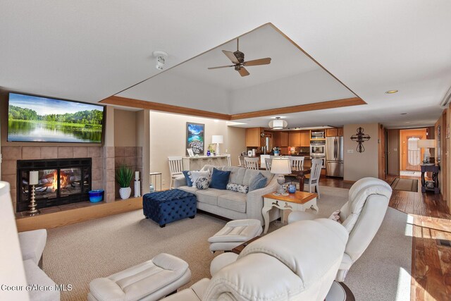 3574 E Tobler Rd # C16, Hayden, ID 83835 - living area with a tile fireplace, ceiling fan, a tray ceiling, wood finished floors, and carpet