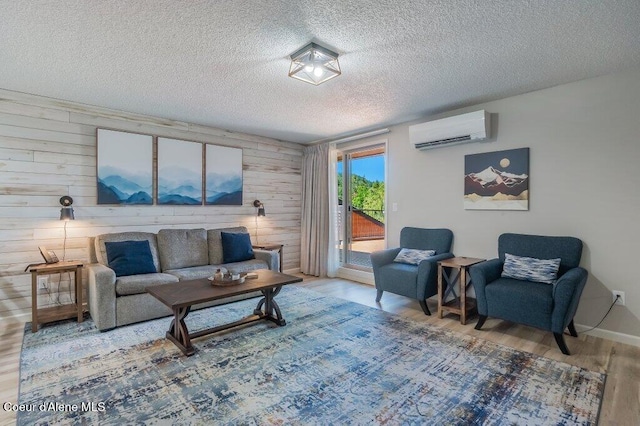 112 Holiday Loop Unit 838, Blanchard, ID 83804 - living area with an AC wall unit, wood finished floors, wood walls, a textured ceiling, and baseboards
