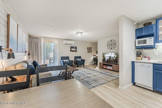 112 Holiday Loop Unit 838, Blanchard, ID 83804 - living room with a wall mounted AC, light wood-style flooring, baseboards, and a textured ceiling