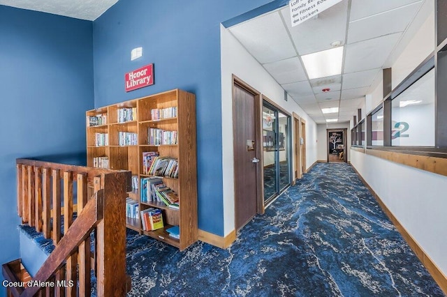 112 Holiday Loop Unit 838, Blanchard, ID 83804 - hall with carpet floors, baseboards, an upstairs landing, and a paneled ceiling