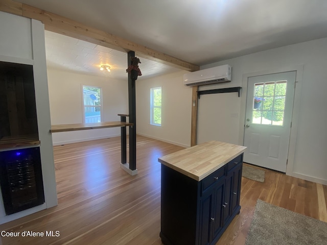 118 Faye St, Mullan, ID 83846 - kitchen with wooden counters, a wall mounted AC, healthy amount of natural light, light wood-style floors, and beam ceiling