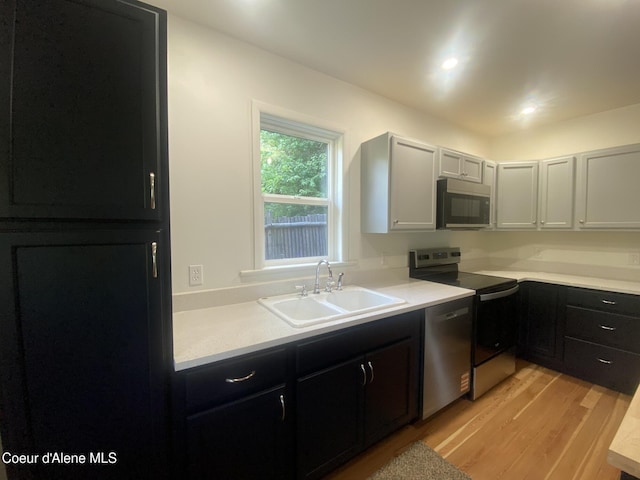 118 Faye St, Mullan, ID 83846 - kitchen featuring appliances with stainless steel finishes, dark cabinetry, light wood-type flooring, light countertops, and recessed lighting