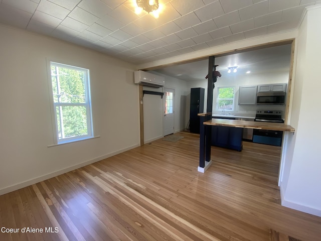 118 Faye St, Mullan, ID 83846 - kitchen with a wall unit AC, stainless steel appliances, light wood-type flooring, and crown molding