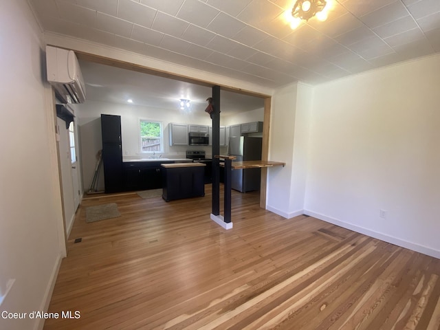 118 Faye St, Mullan, ID 83846 - unfurnished living room featuring a wall mounted AC, light wood finished floors, and crown molding