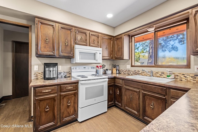 1364 C St, Plummer, ID 83851 - kitchen with white appliances, a sink, light wood-style flooring, and light countertops