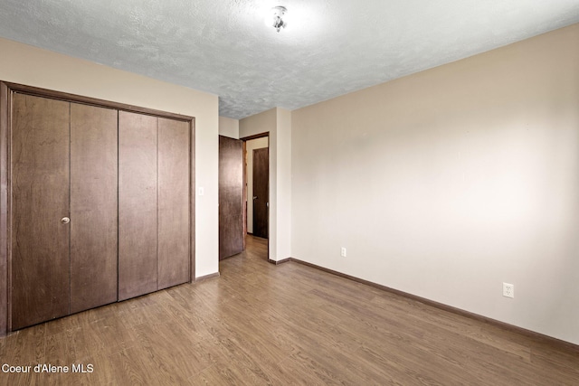 1364 C St, Plummer, ID 83851 - unfurnished bedroom featuring wood finished floors, baseboards, a closet, and a textured ceiling