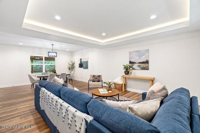 122 Cottonwood Dr, Sagle, ID 83860 - living room featuring a tray ceiling, recessed lighting, wood finished floors, and a chandelier