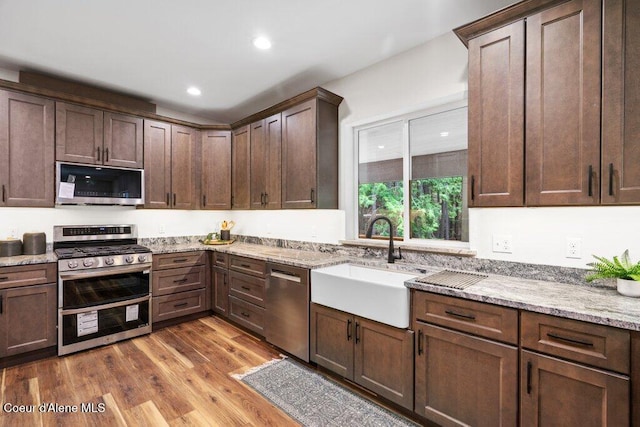 122 Cottonwood Dr, Sagle, ID 83860 - kitchen featuring stainless steel appliances, wood finished floors, light stone countertops, recessed lighting, and dark brown cabinetry