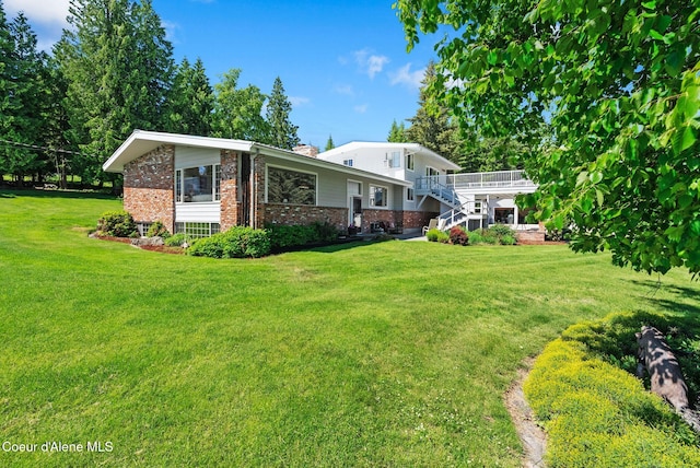 10851 W Pine St, Sandpoint, ID 83864 - rear view of property with brick siding, a chimney, and a yard