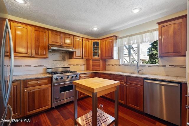10851 W Pine St, Sandpoint, ID 83864 - kitchen with appliances with stainless steel finishes, under cabinet range hood, a textured ceiling, backsplash, and recessed lighting