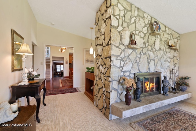 10851 W Pine St, Sandpoint, ID 83864 - carpeted living area featuring lofted ceiling, a chandelier, and a stone fireplace