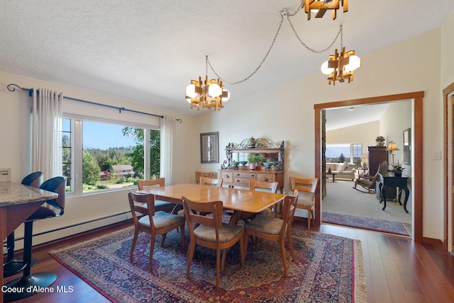 10851 W Pine St, Sandpoint, ID 83864 - dining space with a chandelier, a baseboard radiator, hardwood / wood-style floors, and vaulted ceiling