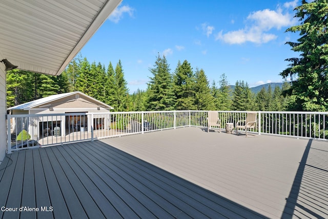 10851 W Pine St, Sandpoint, ID 83864 - wooden deck featuring an outbuilding and a forest view