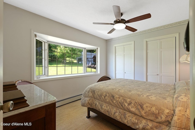 10851 W Pine St, Sandpoint, ID 83864 - bedroom featuring baseboard heating, two closets, and ceiling fan