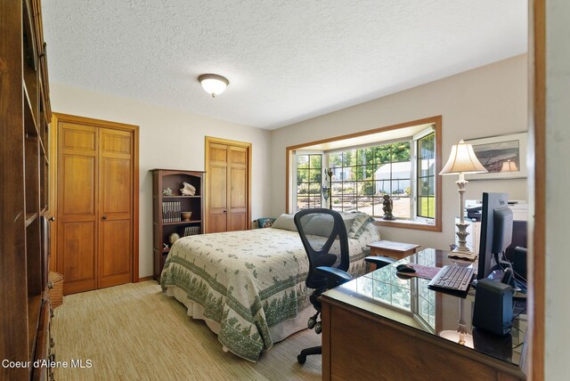 10851 W Pine St, Sandpoint, ID 83864 - bedroom featuring an office area, multiple closets, and a textured ceiling
