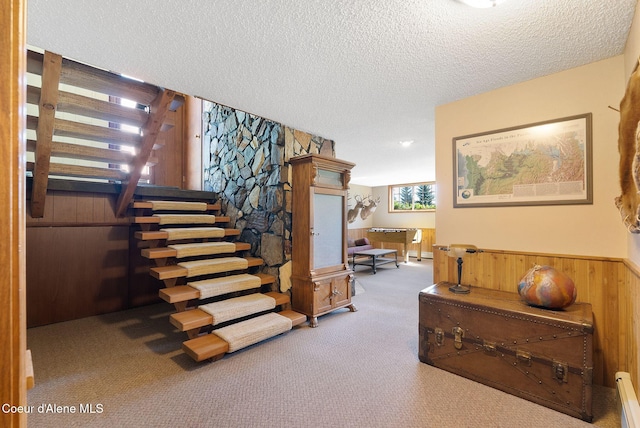 10851 W Pine St, Sandpoint, ID 83864 - staircase with carpet flooring, a textured ceiling, wood walls, and a baseboard heating unit