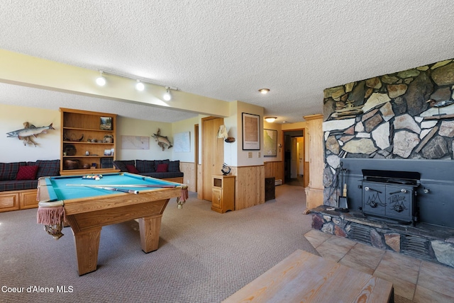 10851 W Pine St, Sandpoint, ID 83864 - rec room with wainscoting, light colored carpet, a textured ceiling, a wood stove, and pool table