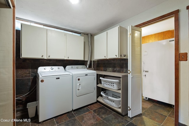 10851 W Pine St, Sandpoint, ID 83864 - laundry area featuring cabinet space, separate washer and dryer, and stone tile flooring