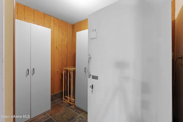 10851 W Pine St, Sandpoint, ID 83864 - hallway featuring dark stone finish floors and wood walls