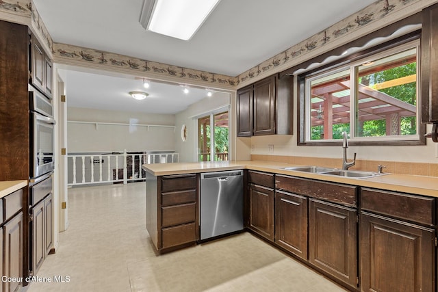 221 S Ridgewood Dr, Post Falls, ID 83854 - kitchen featuring stainless steel appliances, light flooring, light countertops, and dark brown cabinets