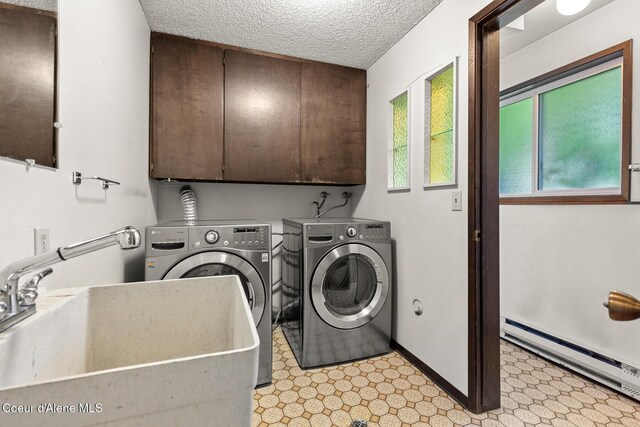 221 S Ridgewood Dr, Post Falls, ID 83854 - laundry room featuring baseboard heating, cabinet space, independent washer and dryer, a textured ceiling, and light flooring