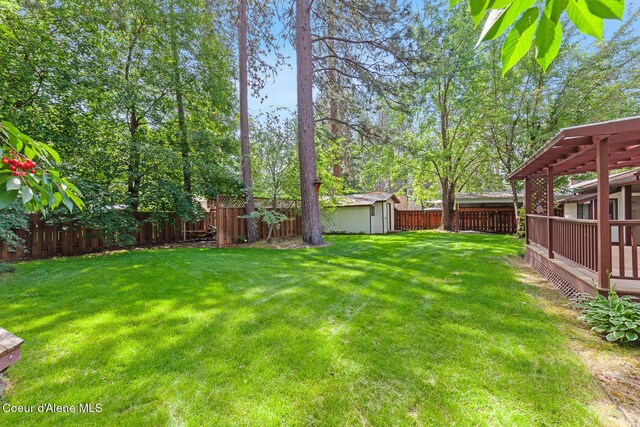 221 S Ridgewood Dr, Post Falls, ID 83854 - fenced backyard featuring a shed and a wooden deck