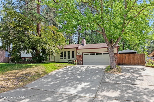 221 S Ridgewood Dr, Post Falls, ID 83854 - view of front of house with driveway, a garage, brick siding, and a chimney